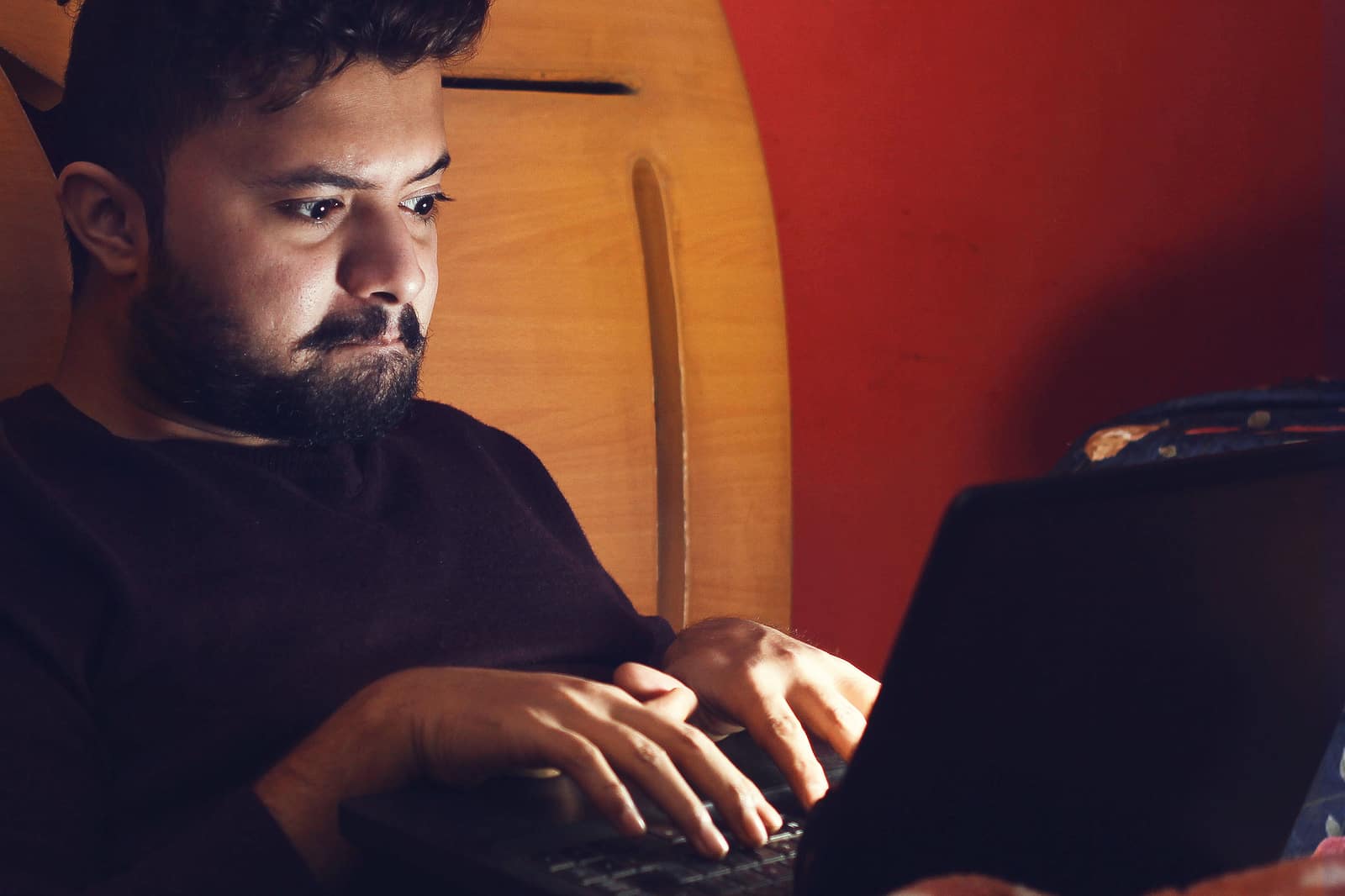 Young hacker looking at laptop